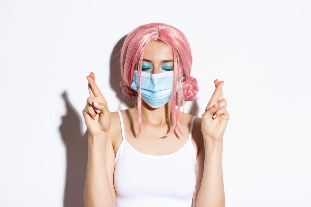 Person with pink hair wearing a medical mask