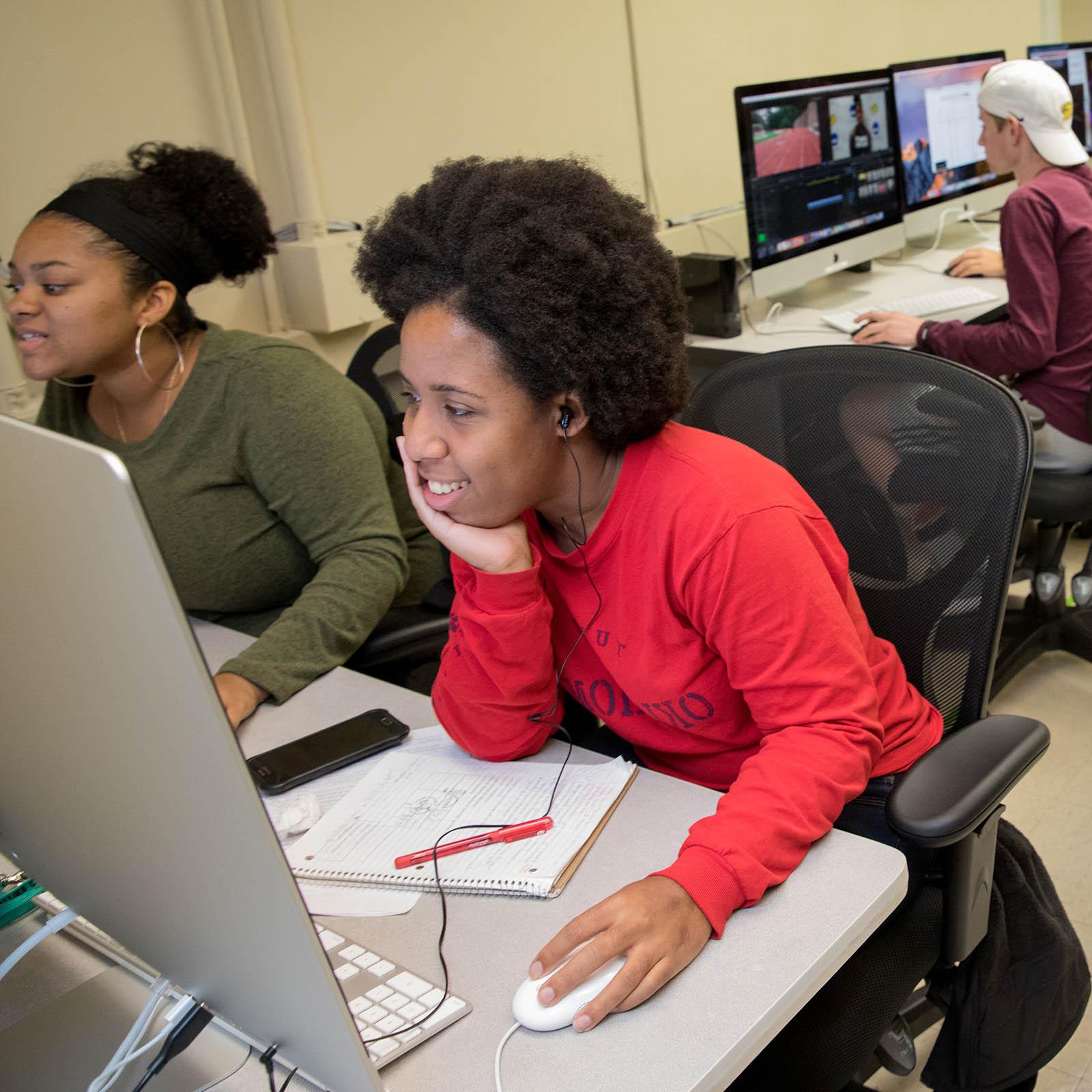 Female students edit video in the Randolph College media lab.