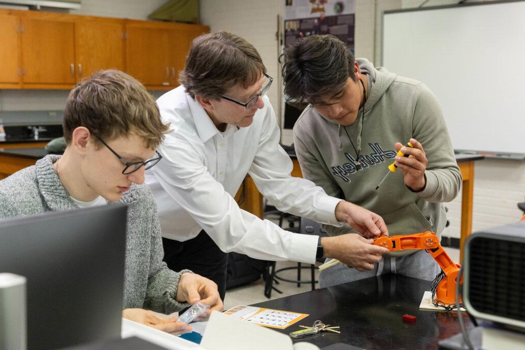 Randolph College engineering students build a robotic arm in a lab session.