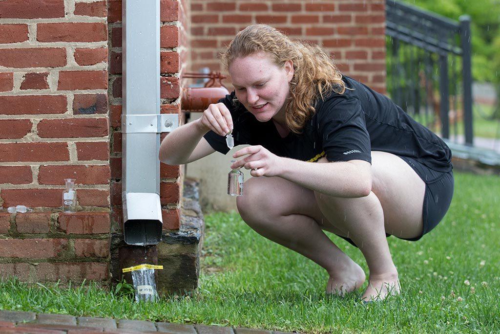 Environmental science student tests the quality of rainwater draining off of campus rooftops.